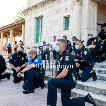 A group of police officers kneeling on steps.