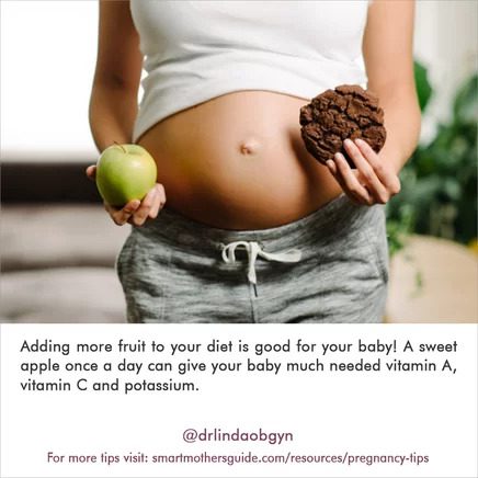 A pregnant woman holding an apple and chocolate covered cookie.