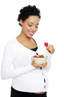 A woman holding a bowl of strawberries and smiling.