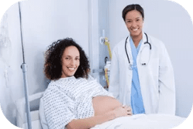 A pregnant woman in hospital bed with doctor.