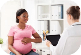 A woman in pink shirt talking to a doctor.